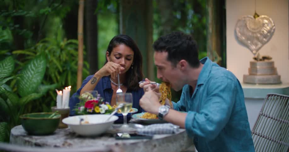 A couple talk and have dinner together