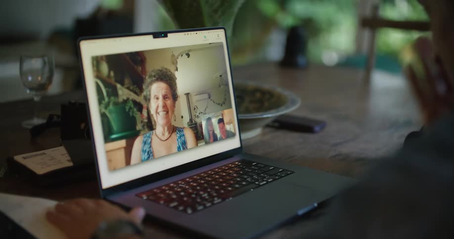 A man is having a video conversation with a woman on a laptop computer