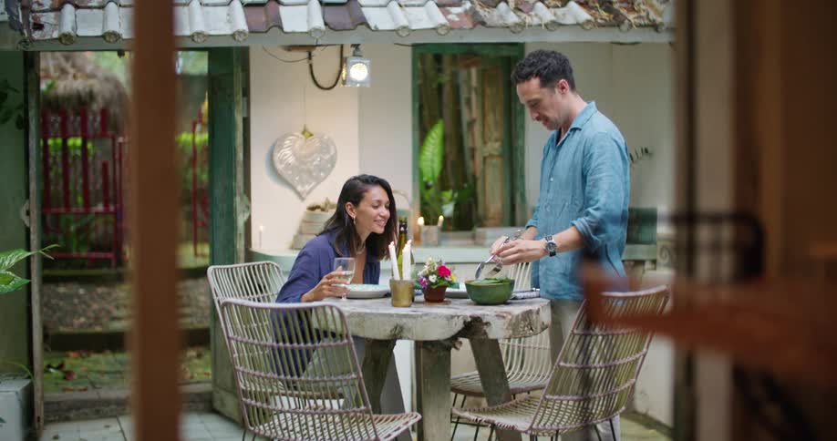 Man brings food to table to share with spouse or girlfriend
