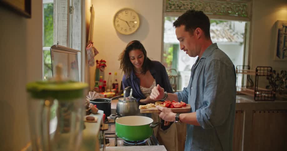 Happy couple cooking a meal in the kitchen at home together