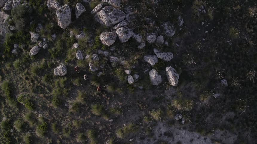 People are hiking below on a hill