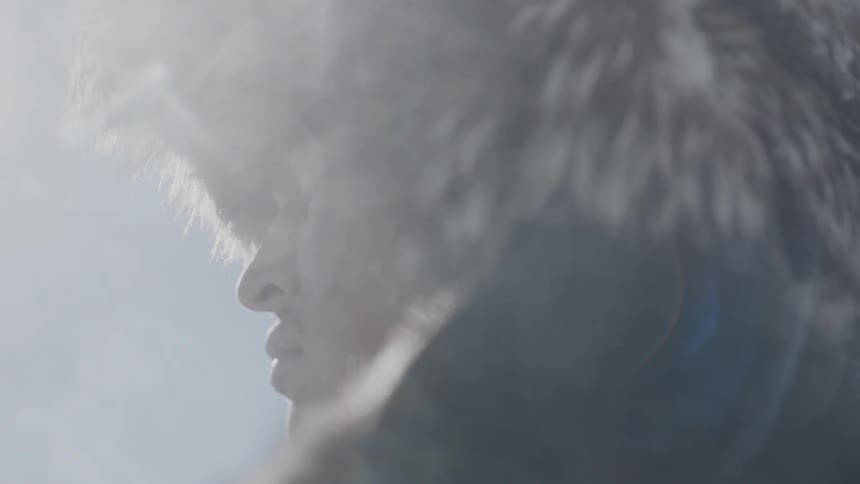A man is standing under the sun before closing his eyes