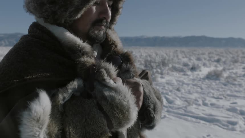 A man in a parka stands in the frozen tundra