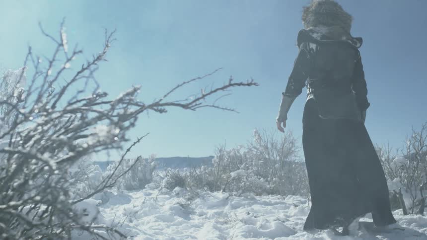 A man hikes in the snow on a sunny day