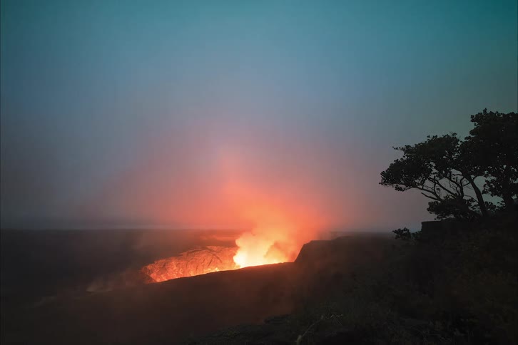Flames and smoke are rising up from a volcanic crater