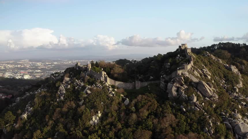 A castle sits along a steep mountain