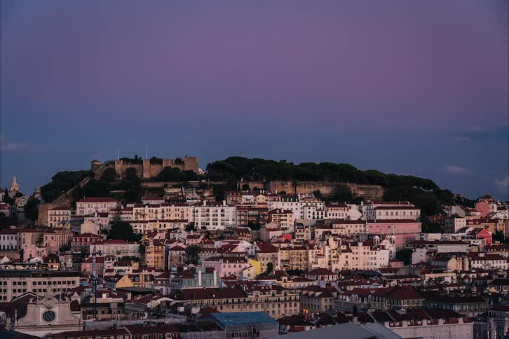 The sun setting over hillside buildings