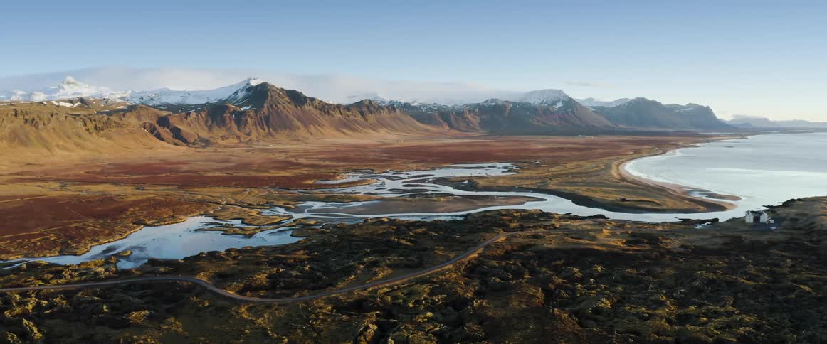 A river flows through a valley into a large lake
