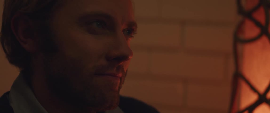 A man is smiling and blinking