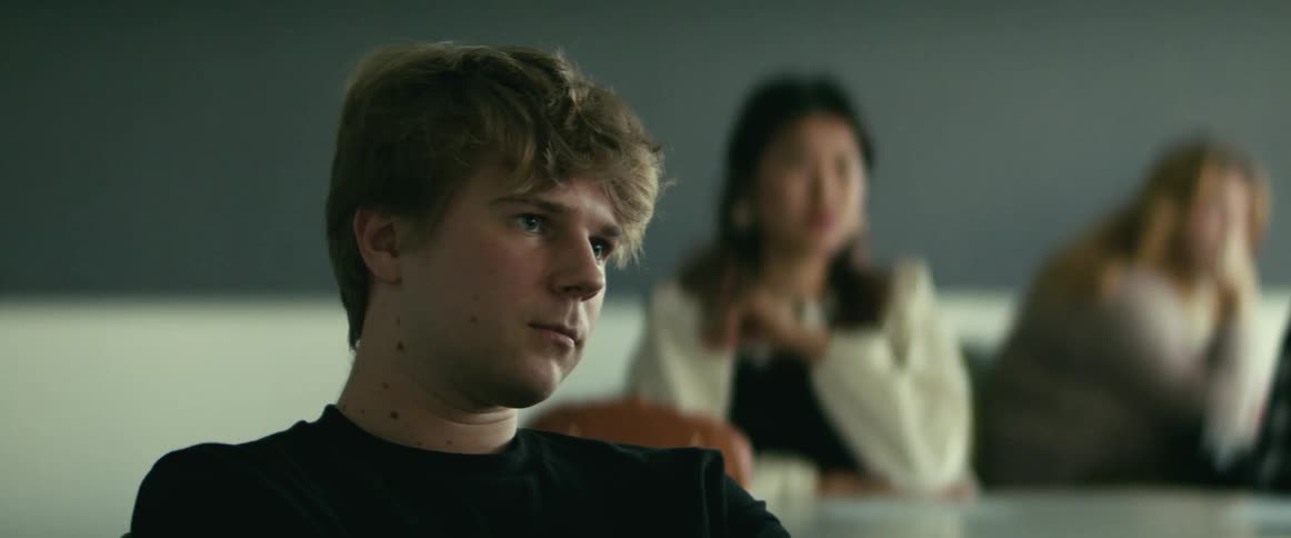 Students are sitting in a classroom in front of a chalkboard