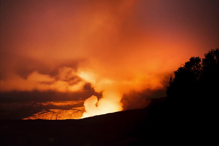 Steam rising from a volcano at night