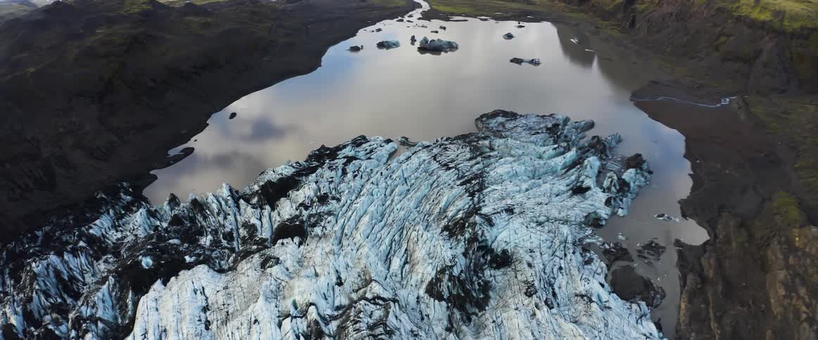 Dirty snow by a calm lake in the wilderness