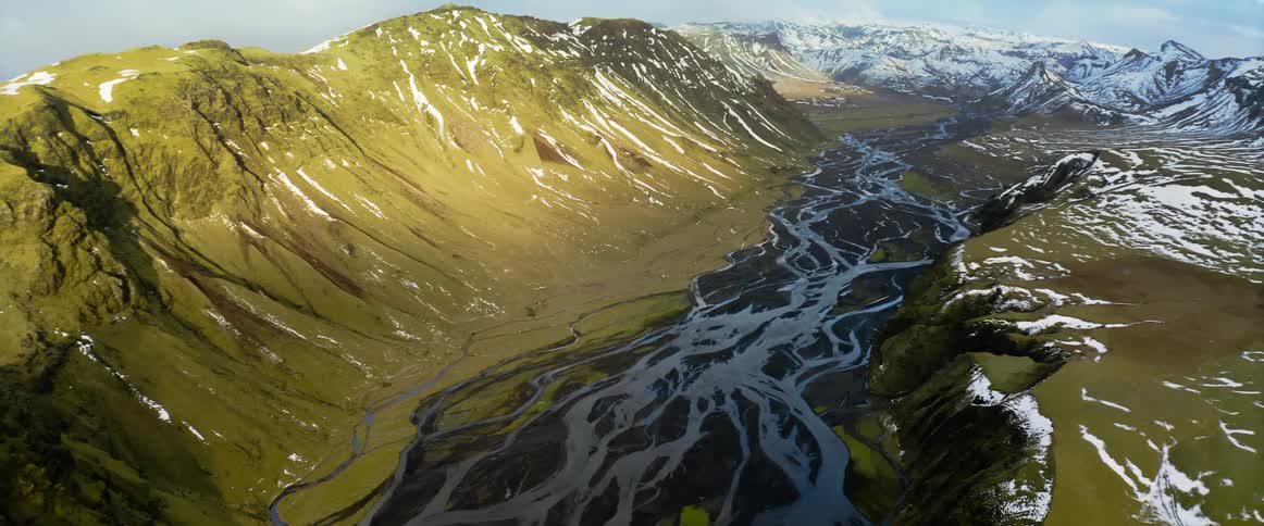 An aerial view of rivers and snowy mountains