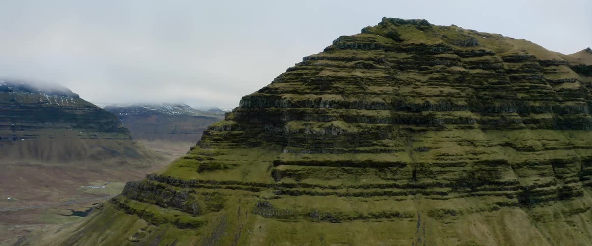 A river runs through a canyon between mountains that have been carved for eons by water