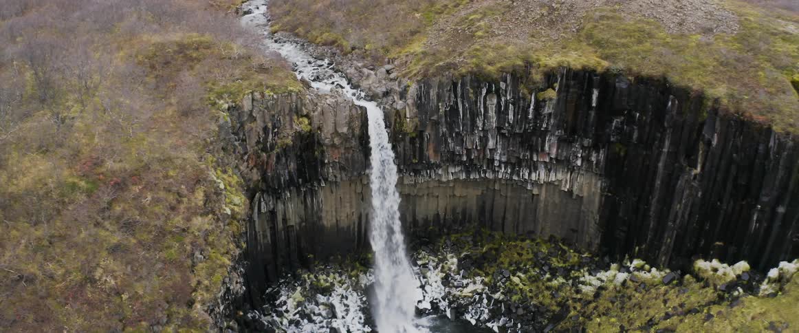 A river crashes down in a waterfall into a rocky canyon