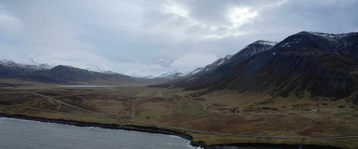 An aerial view of snowy mountains on a coastline