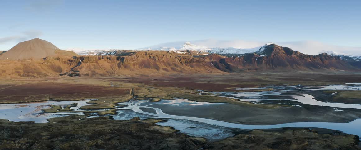 An aerial view of a river and mountains in winter