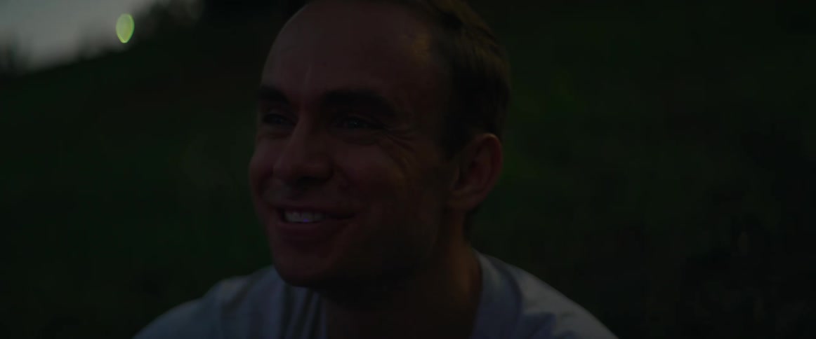 Man smiles happily while watching fireworks