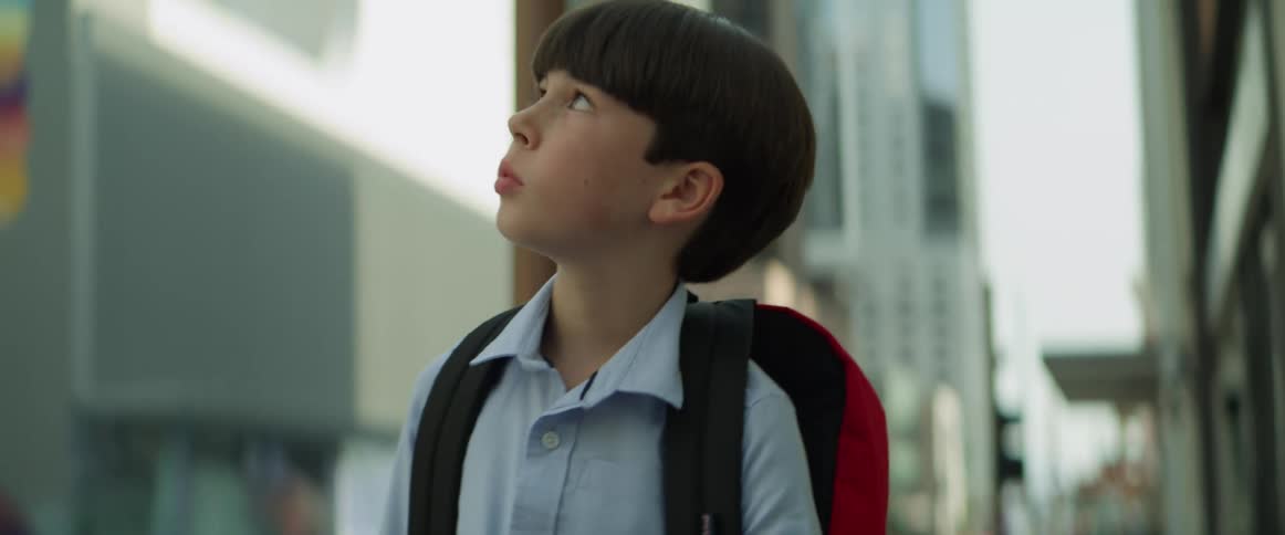 Boy walks forward and stops to look around and get his bearings