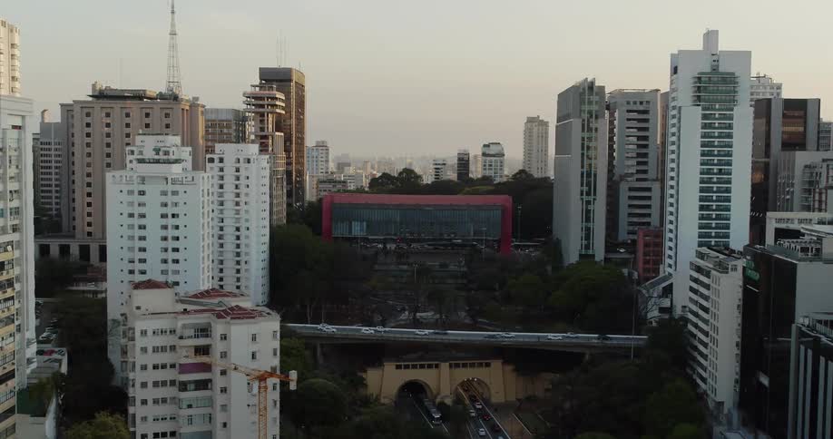 Camera pans towards a cityscape as cars drive by on a bridge and roadway