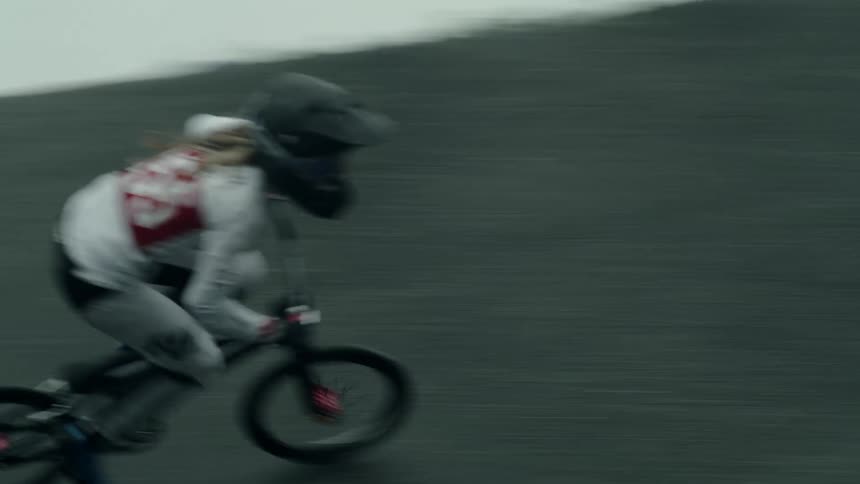Woman wearing motorcycle helmet practicing bmx on an obstacle course