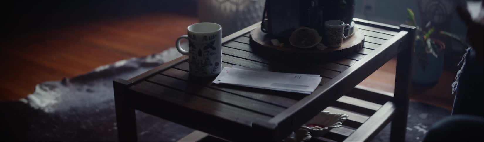 Woman entering the living room carrying the mail finds a letter with a final notice from a creditor