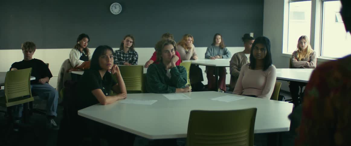 College students sitting at desks listen to professor giving lecture in class