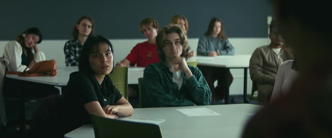 College students sitting at desks listen to professor giving lecture in class