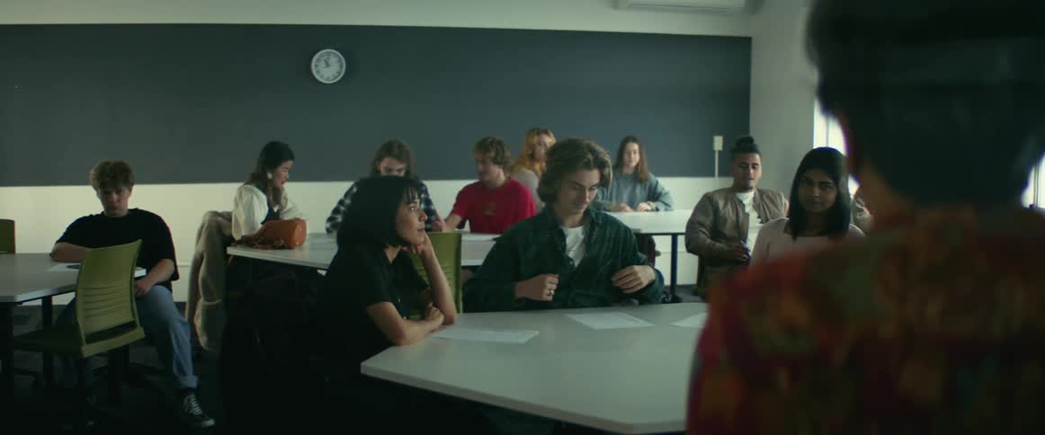 Students talk amongst themselves during a lecture from a teacher