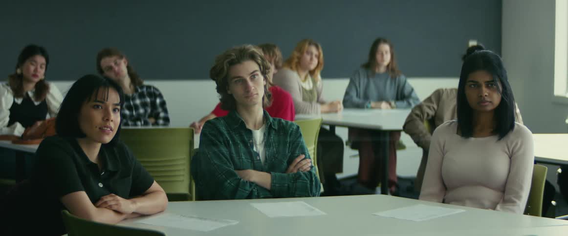 College students sitting at desks listen to professor giving lecture in class