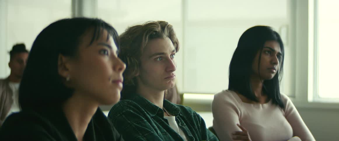 College students sitting at desks listen to professor giving lecture in class