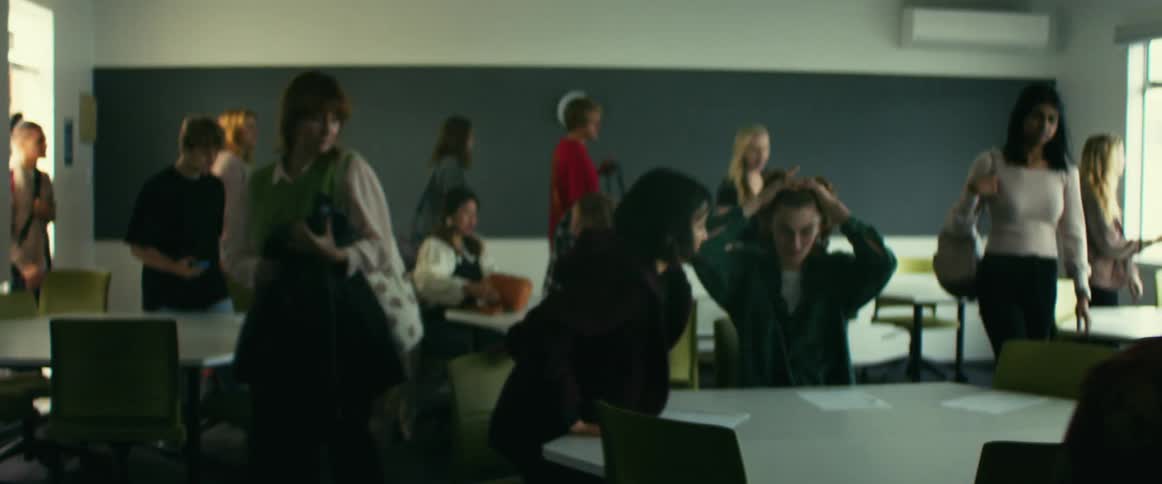 A group of people going to sit down in a classroom