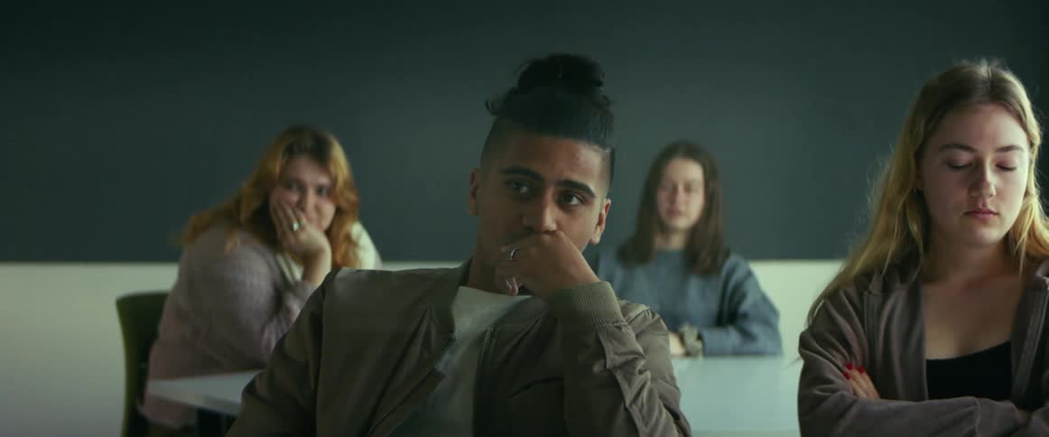 Latino man and other students sitting in the classroom watching the class