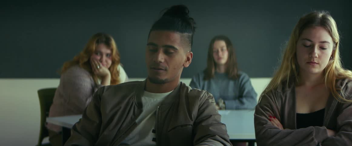 College students sitting at desks listen to professor giving lecture in class