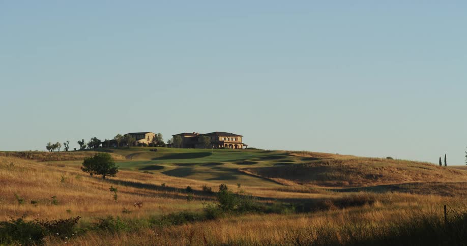 Shot of a large house atop rolling hills