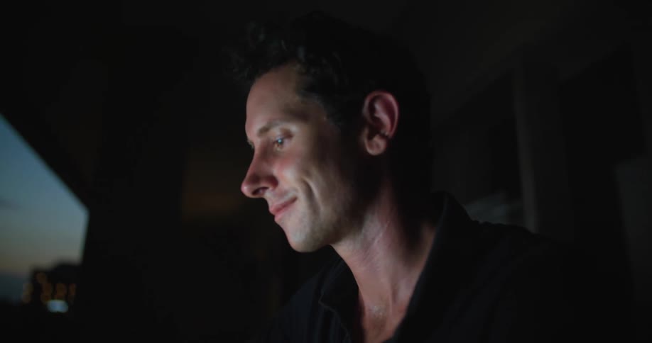 Camera zooms to a man as he turns his head and smirks