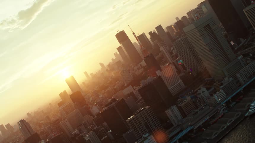 The sun shining golden on tokyo city skyscrapers highways and waterfront