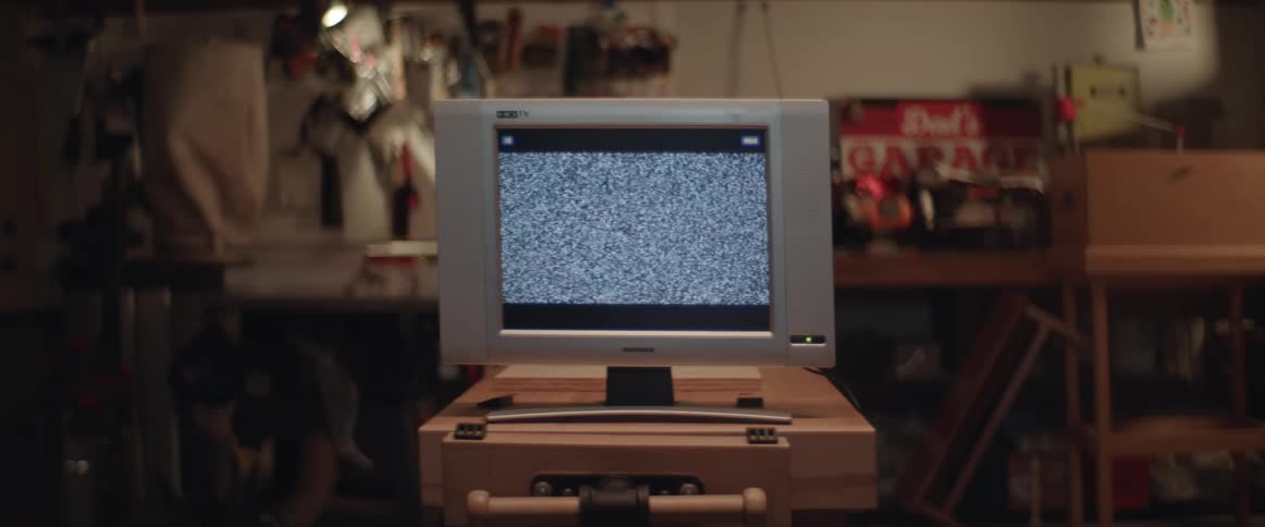 Static comes on a small television in an apartment