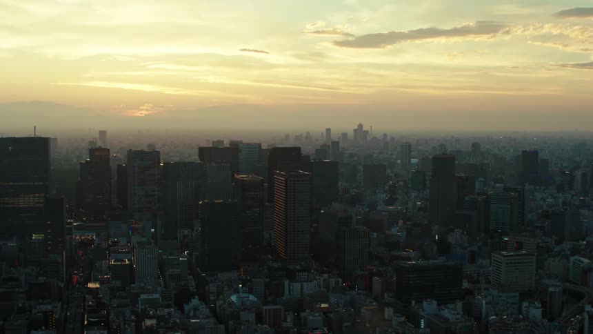 An aerial view of silhouetted skyscrapers at sunrise