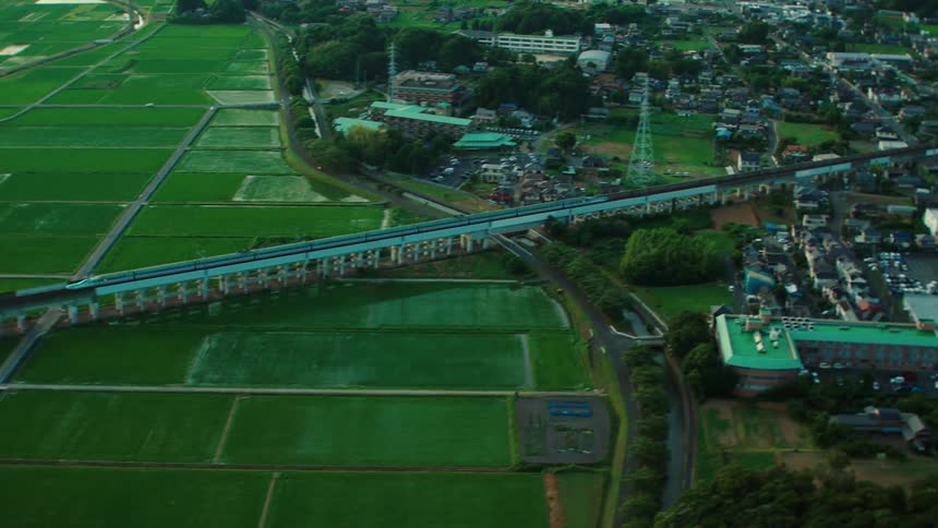 A train travelling across a grassland and through a town