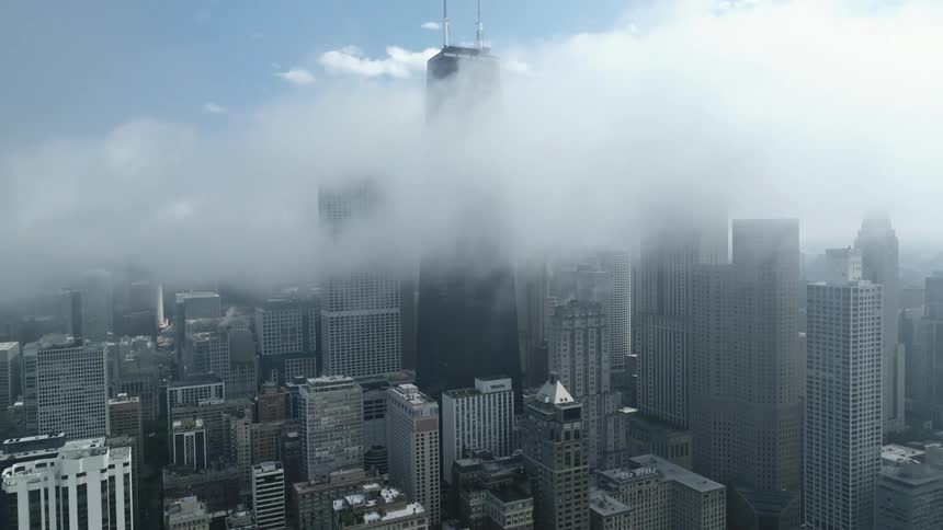 Clouds cover the top of the buildings