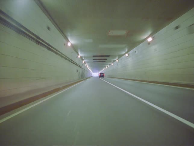 A car is driving through an underground tunnel