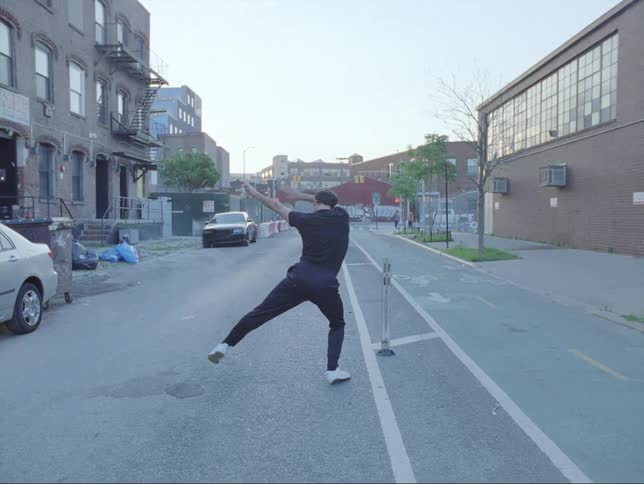 A man is dancing on the street in an urban city