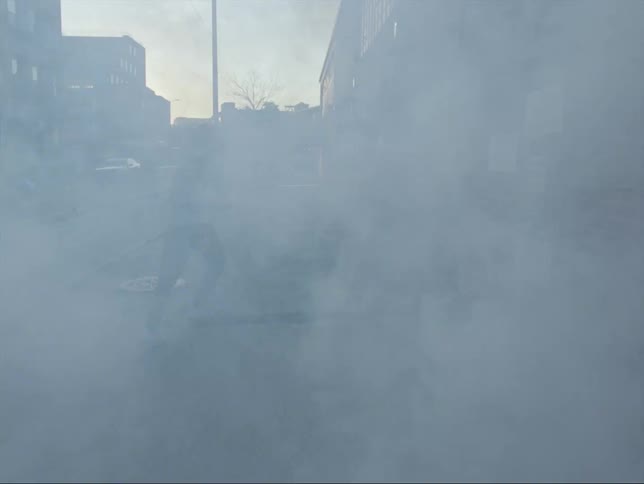 A man is stretching his legs in a downtown city