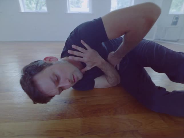 A man is doing a dance pose on the wooden floor
