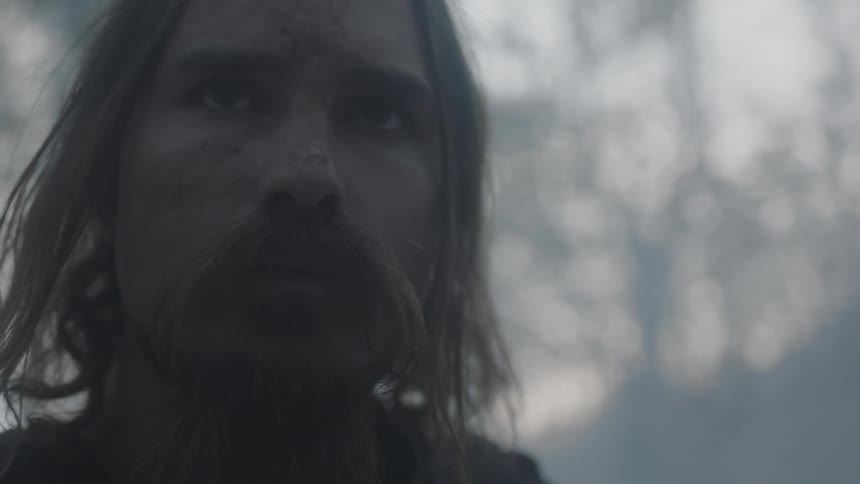 A man looks forward near a forest