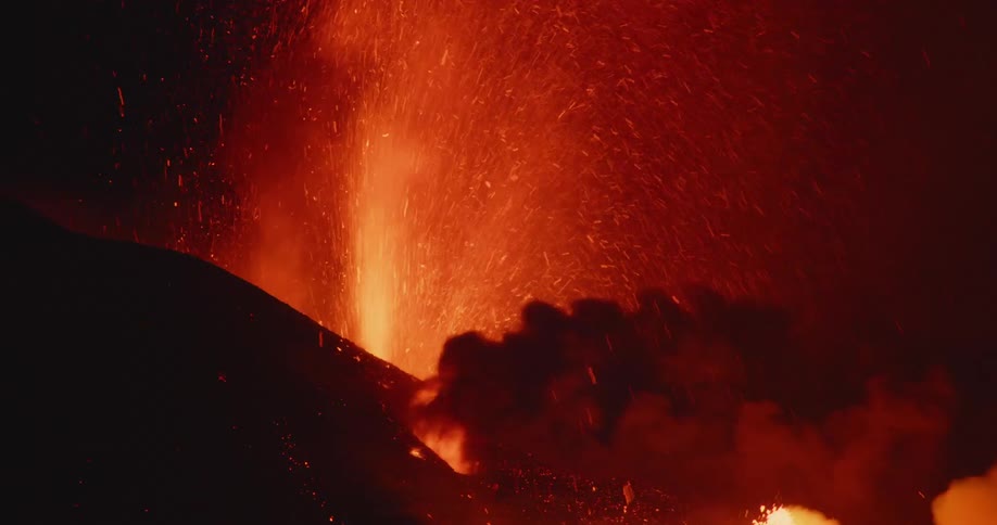 Smoke and embers pour out of an erupting volcano
