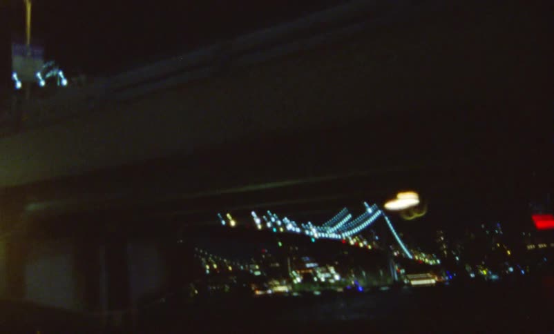 Colorfulbridge lights and city lights can be seen through street rail at night