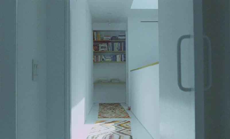 A hallway in a house is displayed during midday