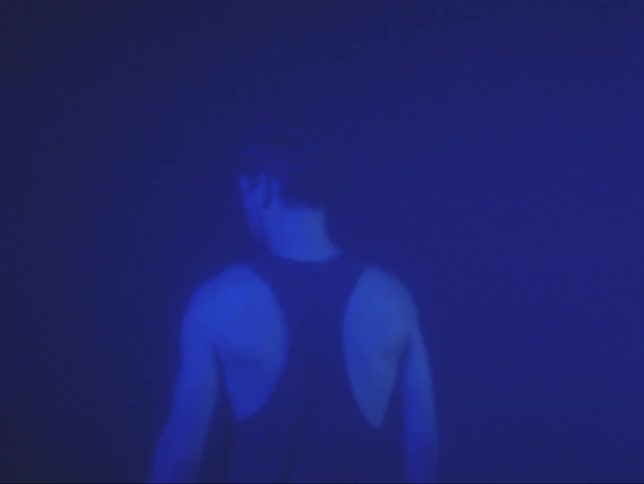 Man colored by blue lighting walks away